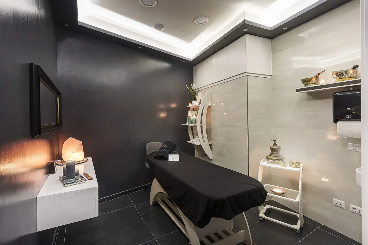 Una cabina trattamenti con lampada di sale e candele